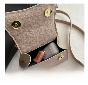 Detailed interior view of a pink pebbled leather crossbody bag showing daily storage capacity