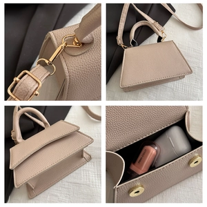 Detail of beige pebble leather bag showing interior capacity and golden hardware