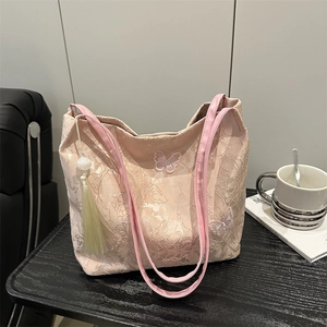 Pale pink lace tote bag featuring embroidered white butterflies and tassel detail