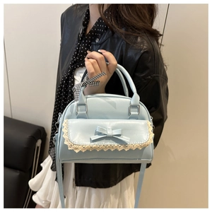 Détail du sac bandoulière bleu clair avec nœud ruban et dentelle blanche en cuir vegan