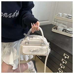Détail du mini sac bandoulière blanc crème avec nœud en cuir et bordure en dentelle