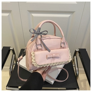 Close-up of pink PU leather handbag with delicate lace trim and plaid ribbon handle