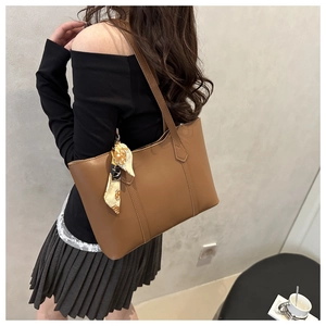 Close-up of brown faux leather tote bag featuring a decorative patterned silk scarf