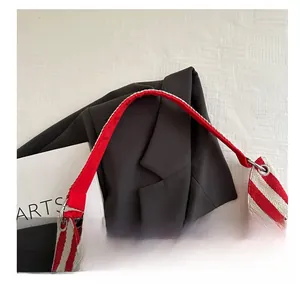 Detail of red and white striped canvas tote showing metal ring strap connection