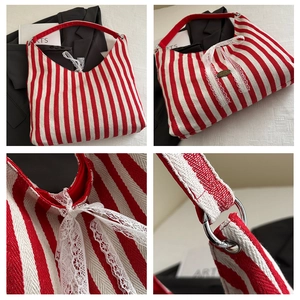 Detail view of red and white striped tote bag with lace bow and silver metal hardware