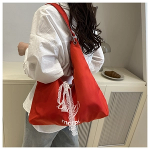 Red canvas tote bag with white mabei print and delicate lace ribbon detail on the strap