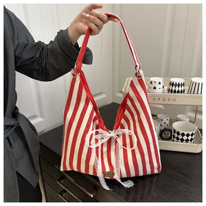 Detail of red striped canvas tote with lace bow and oval metal handmade tag