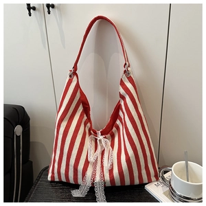 Close-up of red and white striped tote bag featuring a decorative lace bow detail