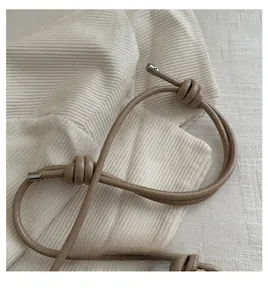 Detail of the soft beige leather strap with decorative knot and silver metal caps