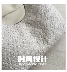 Detail shot of white woven leather handbag texture with a luxury square braid design