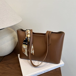 Retro brown leather tote bag for women with a vintage patterned silk scarf on the handle