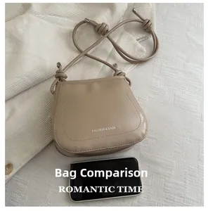 Detailed comparison of khaki PU leather saddle bag size next to a mobile phone