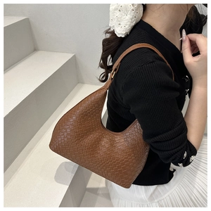 Close-up of brown woven leather texture on a stylish French baguette shoulder bag