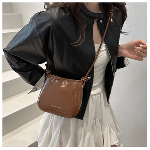 Brown faux leather crossbody bag detail with white Fashion & Bags text on white stairs