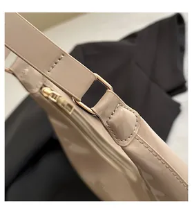 Macro shot of apricot patent leather bag with gold hardware and detailed stitching