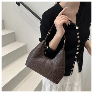 Detailed view of dark brown woven hobo shoulder bag with textured square weave patterns