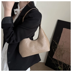 Close-up of beige woven texture and leather details on a luxury vintage hobo shoulder bag