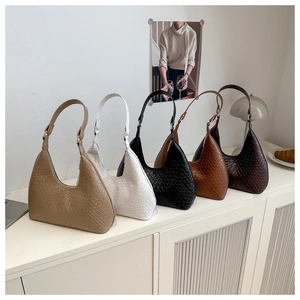 Row of five woven leather hobo bags in assorted earthy colors on a minimalist shelf
