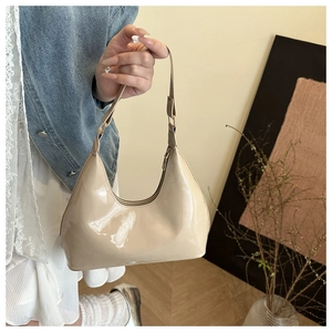 Detail van beige lakleren schoudertas met glanzende metalen ritssluiting voor dames