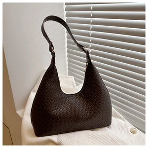 Detail of woven texture and golden buckle on a dark brown faux leather hobo shoulder bag