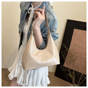 Zijaanzicht van beige laktas hobo model gedragen door een model in een studio