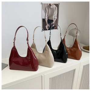 Close-up of gloss patent leather hobo bags in burgundy, beige, black, and caramel colors