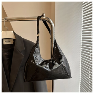 Gedetailleerd beeld van de hoogglans zwarte laklederen hobotas met gladde spiegelafwerking