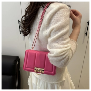 Side view of vibrant pink quilted chain bag worn by a model in a minimalist room