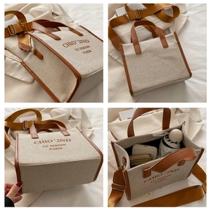 Detailed macro view of the canvas tote bag showing leather handles and adjustable strap
