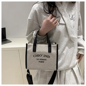 Détail d'un sac cabas en toile beige avec poignées noires et imprimé Paris