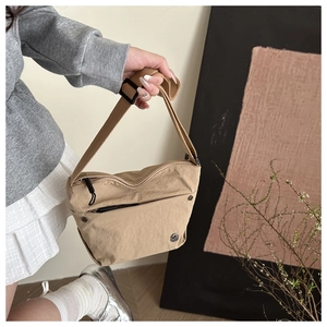 Top view of a khaki nylon crossbody bag with adjustable strap and front zipper pocket