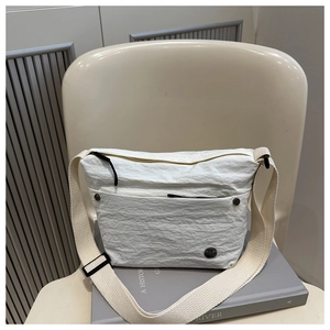Detail of white pleated texture fabric and black zip closure on minimalist crossbody bag