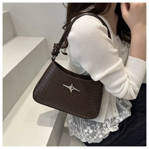 Detail of dark brown faux crocodile texture shoulder bag with silver star ornament