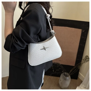 Détail d'un sac à bandoulière blanc gaufré crocodile avec logo étoile en métal argenté