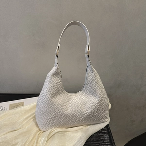 Minimalist white woven hobo bag with a sleek crescent shape and golden hardware accents