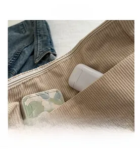 Dettaglio dell'interno della borsa tote in velluto a coste beige con tasca interna