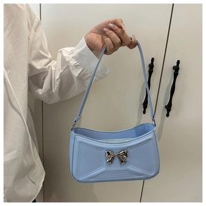 Dettaglio della borsa sottobraccio azzurra con fiocco in metallo argento e zip