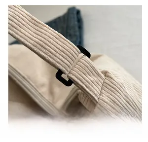 Dettaglio della borsa tote in velluto beige con tracolla rinforzata e fibbia nera