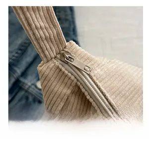 Dettaglio della cerniera scorrevole e trama a coste su una borsa tote color beige