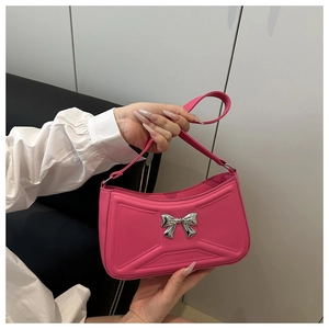 Dettaglio della borsa rosa shocking con trama goffrata e ornamento a fiocco argento
