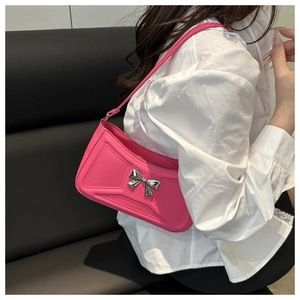 Dettaglio borsa sottobraccio rosa con fiocco argento e trama trapuntata