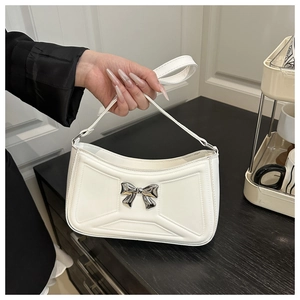 Dettaglio borsa in pelle PU bianca con trama geometrica e fiocco in argento
