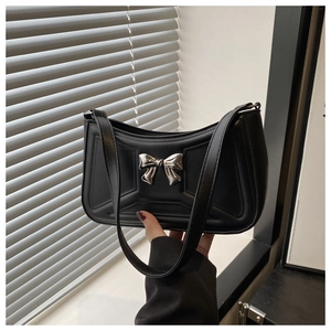 Dettaglio borsa sottospalla in pelle nera con fiocco argento e cuciture geometriche 3D