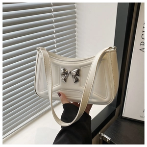 Dettaglio borsa bianca in pelle con motivo geometrico trapuntato e fiocco argento