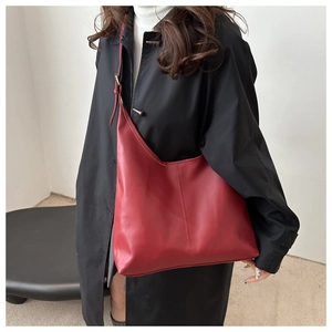 Detail of dark red hobo tote bag with adjustable gold buckle and smooth leather texture