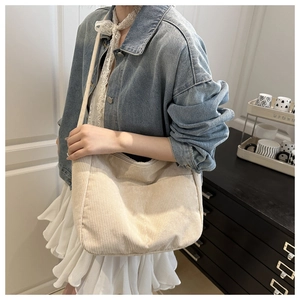 Dettaglio della borsa tote in velluto a coste bianco sporco indossata dalla modella