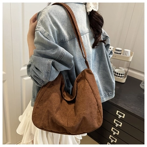 Dettaglio di una borsa tote in velluto a coste marrone con trama a coste e stile casual