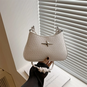 Minimalist white woven shoulder bag with star buckle and knot handle on wooden stool