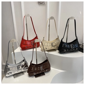 Five assorted studded faux leather underarm bags displayed on a metallic display stand