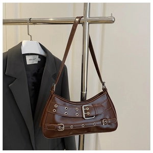 Nahaufnahme der braunen Y2K-Schultertasche mit Metallösen und Schnallenverzierung